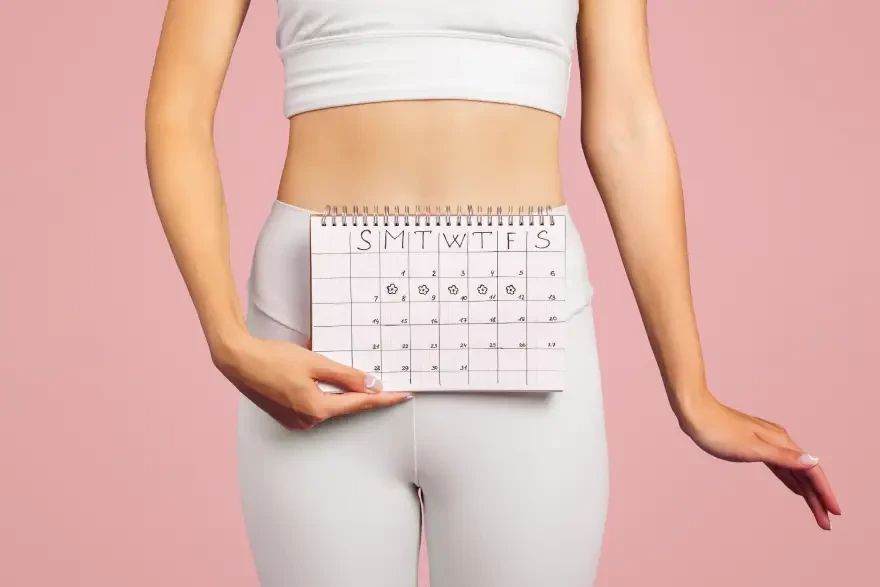 Žena drži kalendar za praćenje menstrualnog ciklusa