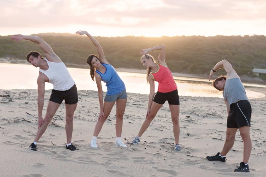 Osobe vežbaju na plaži