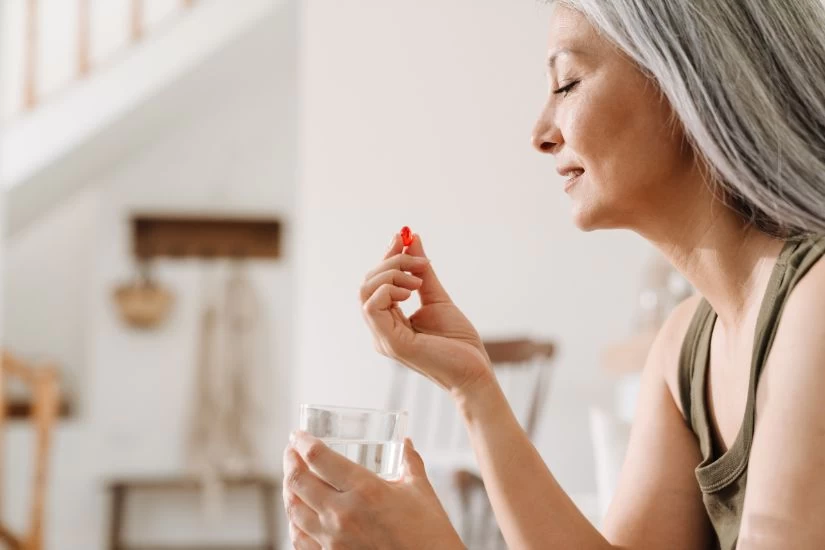 Žena u menopauzi pije suplemente.