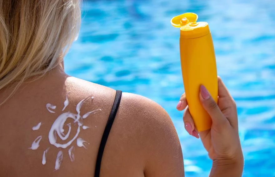 Žena stavlja spf na ledja
