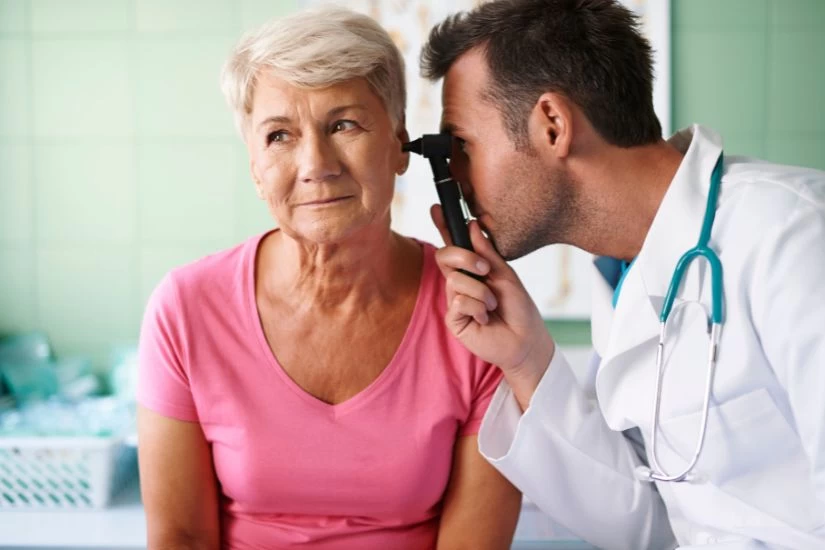 Žena sa upalom uha na pregledu kod lekara.